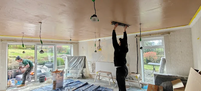 Living room Artex ceiling being plastered in Scarcroft, Leeds, with fresh plaster applied around ceiling light positions