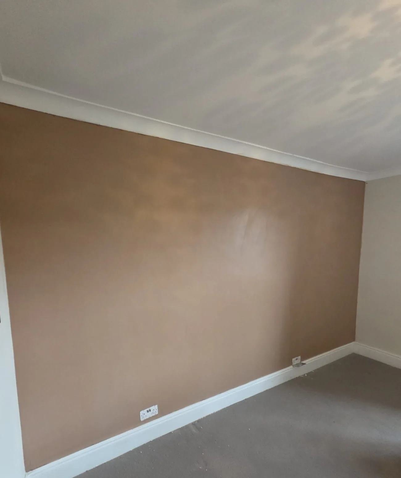 Smooth freshly plastered interior wall above white skirting boards
